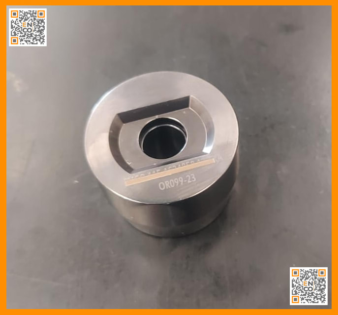 Precision-machined metal die component OR099-23, featuring a D-shaped internal recess surrounding a central circular hole.
