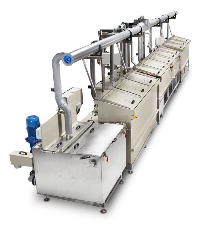 Stainless steel industrial processing line with interconnected tanks, an overhead pipe system featuring a blue end cap, and a visible blue motor, suggesting a multi-stage washing or treatment process.