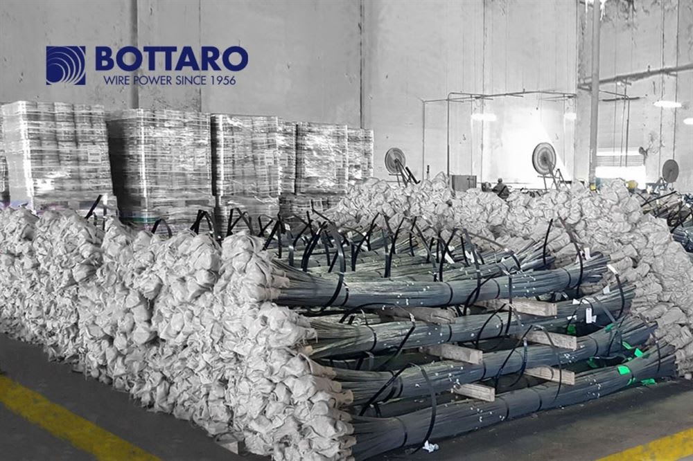Bottaro Industrielager mit großen Mengen gestapelter Drahtbündel und palettierter Produkte.
