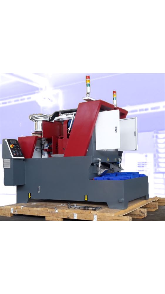 Macchinario industriale automatizzato grigio e rosso per lavorazione o assemblaggio, con alimentatore vibrante, pannello di controllo, luci di segnalazione e contenitori di scarico blu, su pallet in legno.