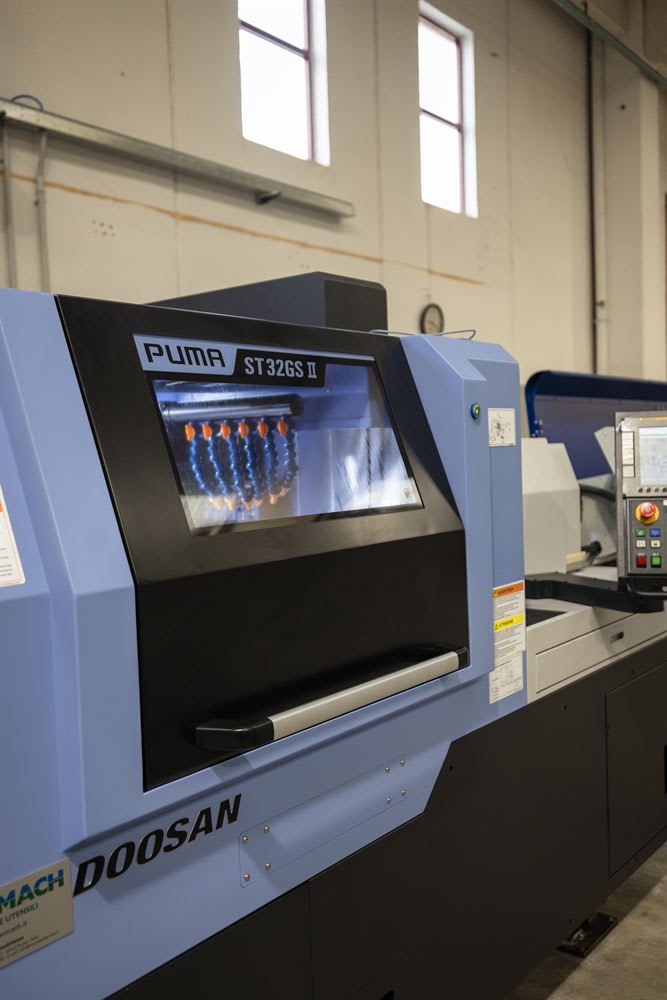Doosan PUMA ST32GS II CNC turning center with its control panel in a brightly lit industrial workshop.