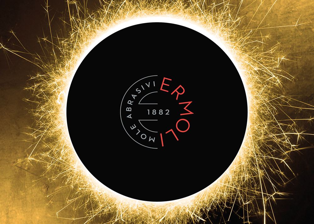 Ermoli Abrasivi Mole logo with '1882' in a black circle, surrounded by bright golden sparklers.