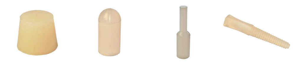 Assortimento di tappi e inserti in gomma o plastica di diverse forme: conico, cilindrico, a stelo e conico scanalato.