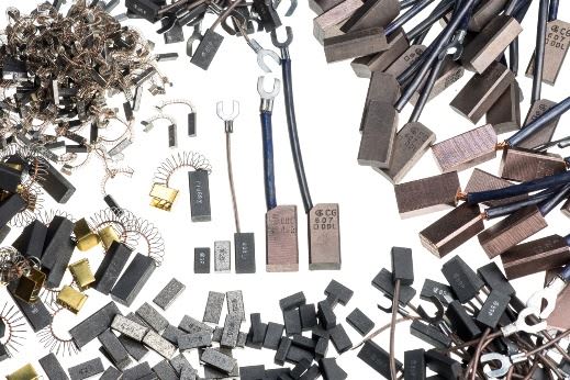 Various carbon brushes for electric motors and generators, including different sizes, shapes, and attached wires, springs, and metallic terminals.