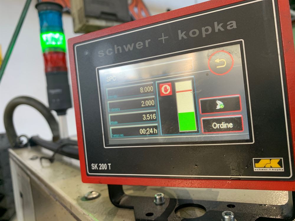 Pannello di controllo industriale Schwer + Kopka SK 200 T con display HMI che mostra dati SPC e una luce di stato verde accesa.