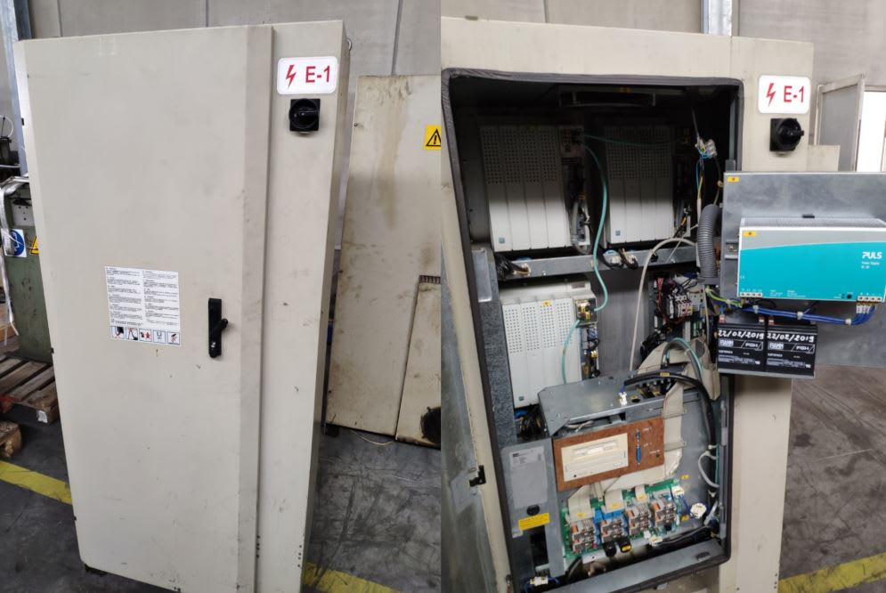 Armadio elettrico industriale aperto che rivela moduli di controllo, alimentatore PULS, batterie e schede elettroniche cablate, con etichetta di pericolo E-1 e sezionatore.