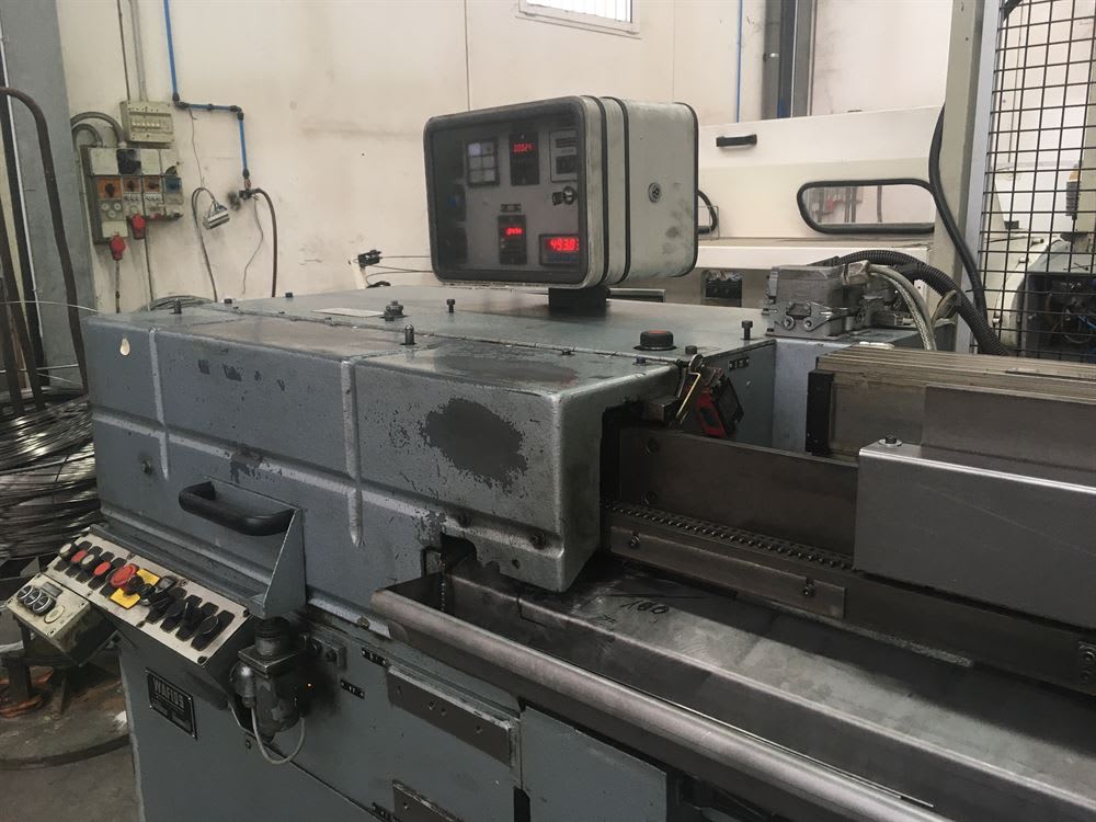 Macchina WAFIOS industriale grigia per la lavorazione del filo metallico, dotata di pannello di controllo digitale e meccanismo di alimentazione, in un'officina.
