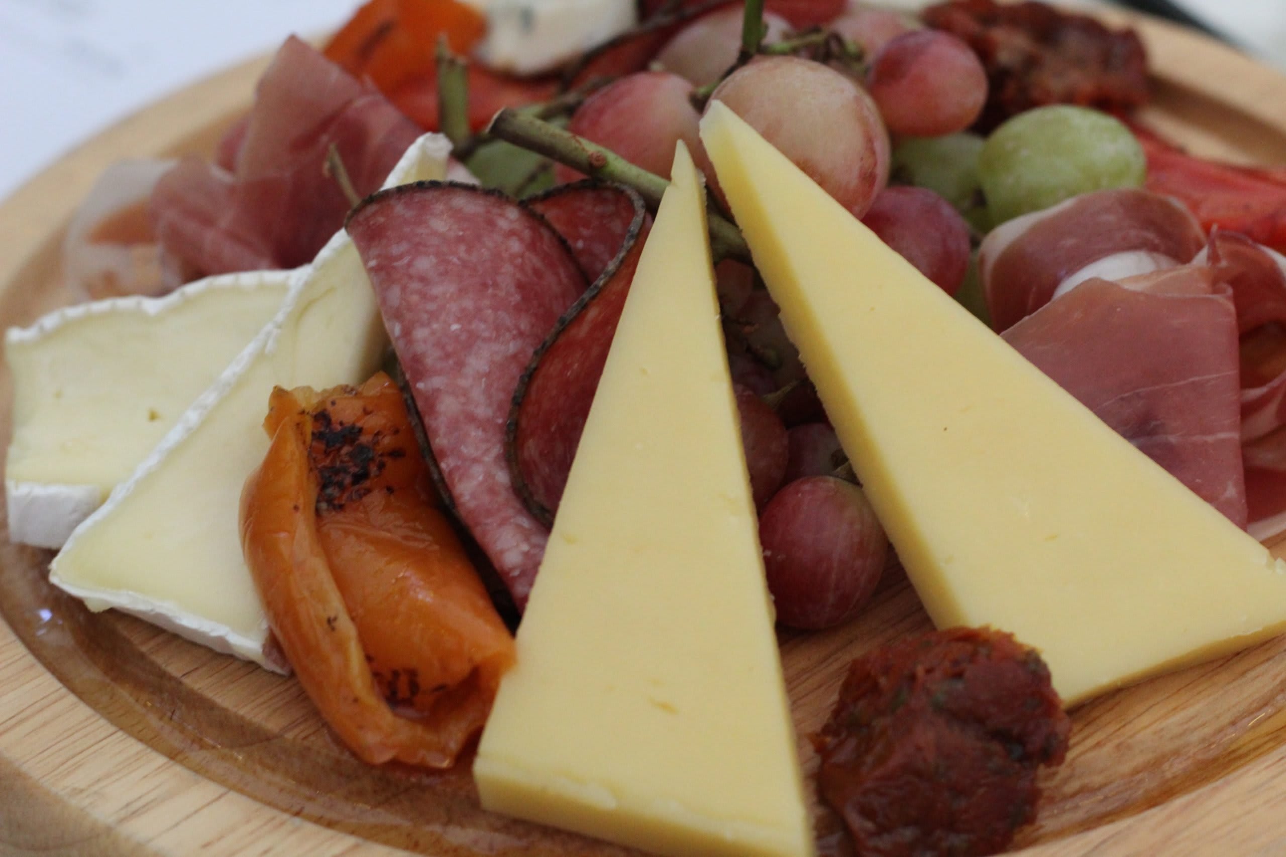 antipasti board, cheese meat grapes prosciutto italian treats