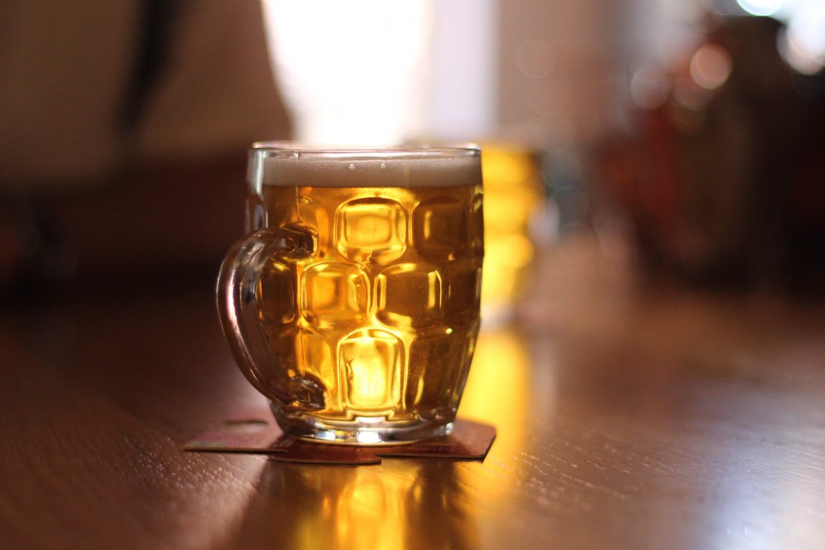 Half pint of ale sitting on a bar