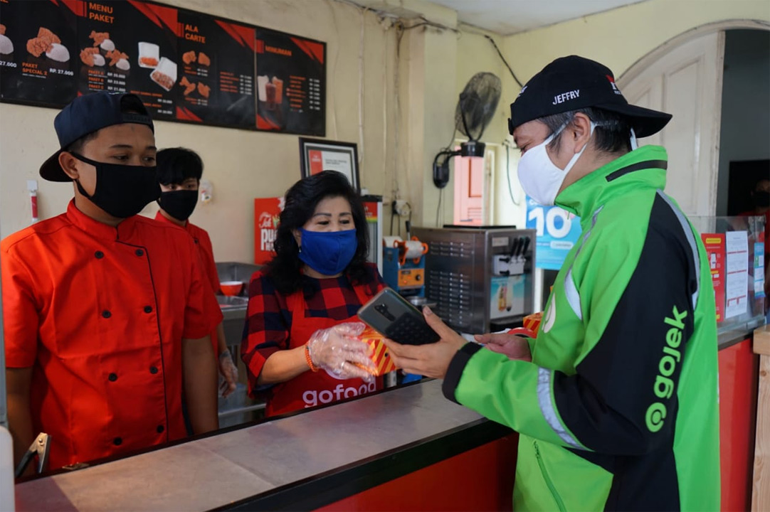 A Gojek driver orders food from a restaurant for his customer amid coronavirus pandemic