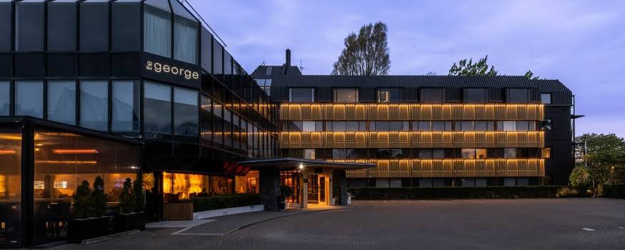 Facade of The George hotel facing the trees of Hagley Park in Christchurch