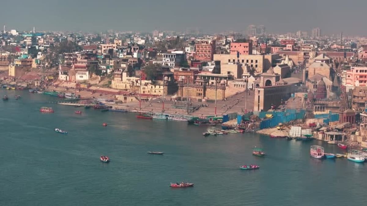 Sacred stone steps of Manikarnika Ghat with wood stacks and ancient riverfront architecture