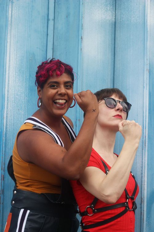 Two F*Choir singers flex their biceps outside Matchstick Piehouse.