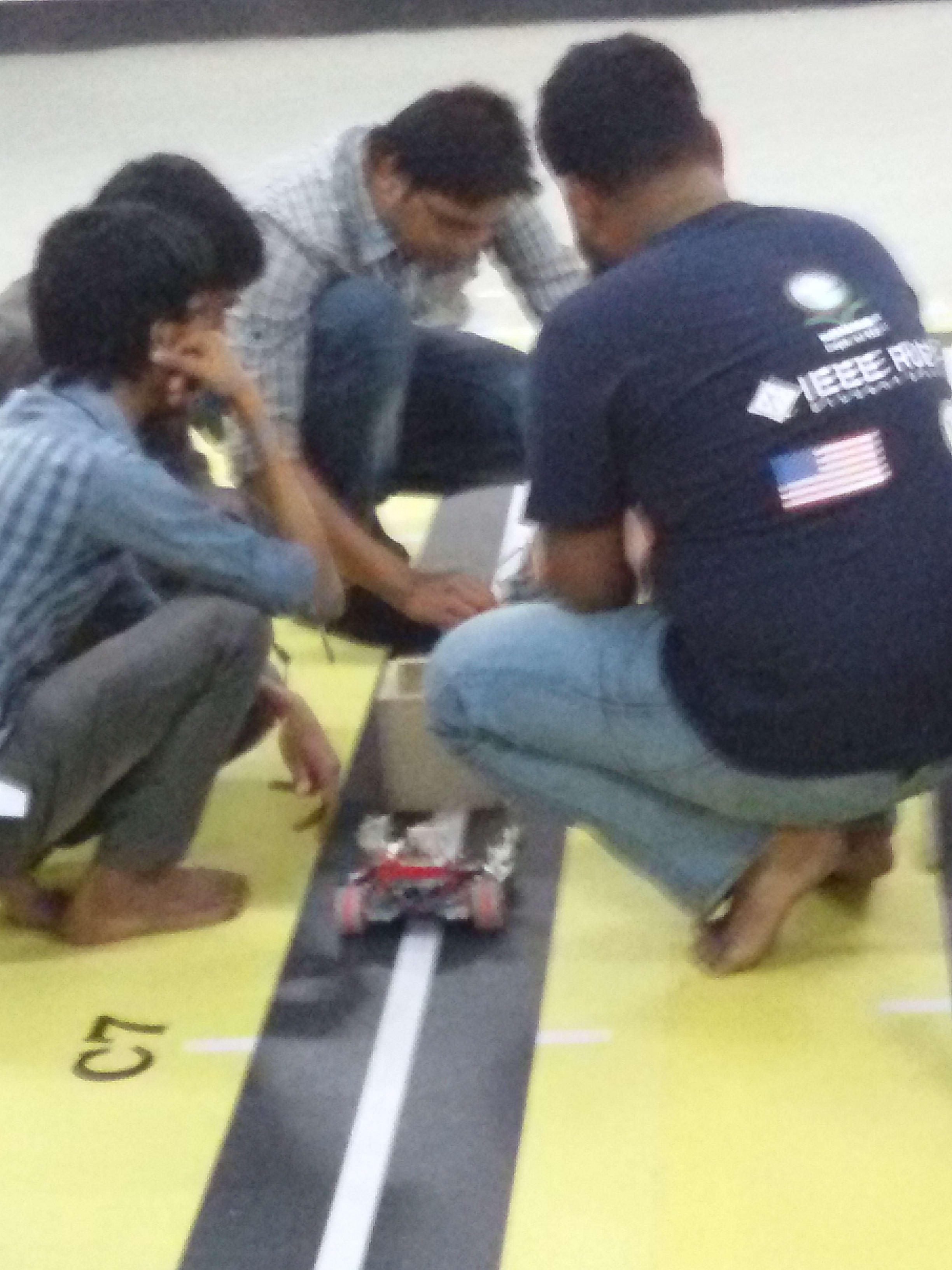 Placing our line follower robot on the track under the eye of the IEEE RUET organising team