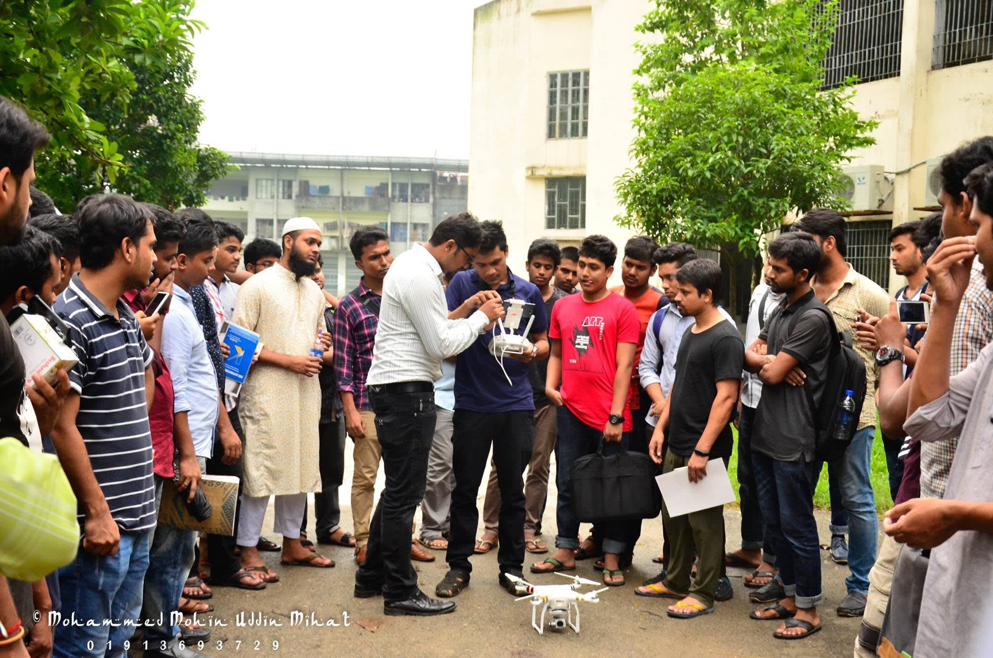 Setting up a camera drone and its controller with participants outdoors