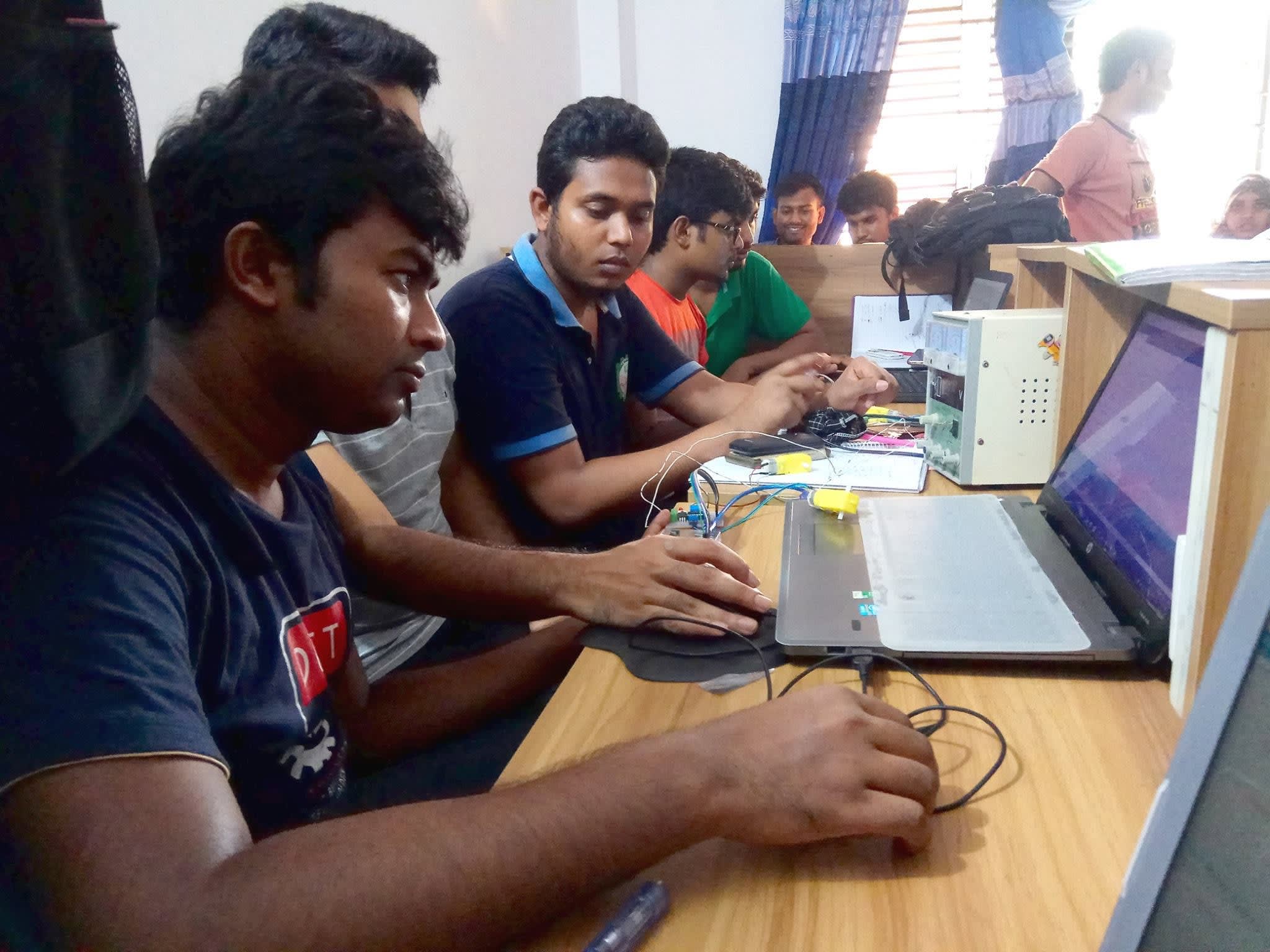 Participants wiring an Arduino, motor driver and geared motors for their robots