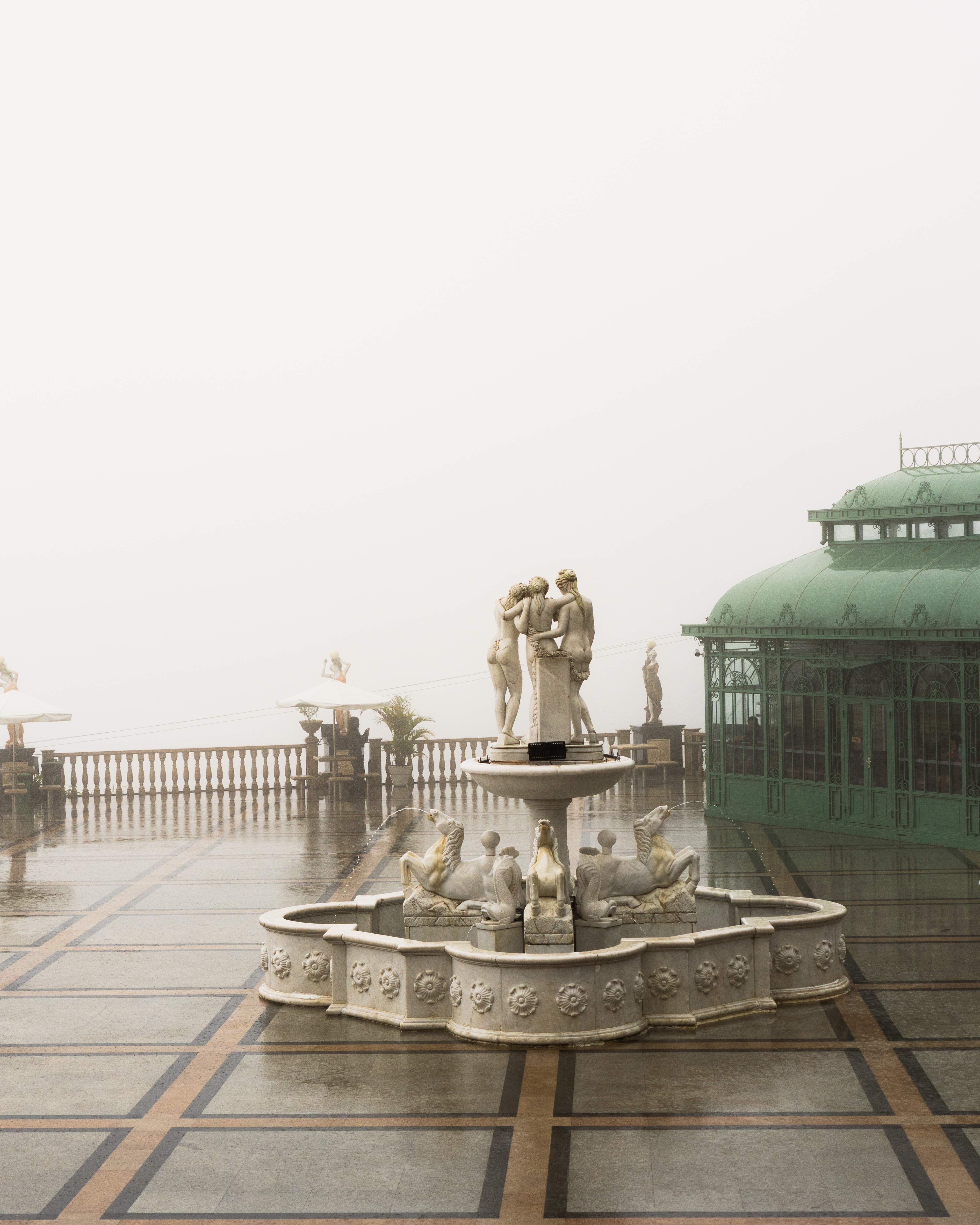 White marble fountain with classical sculptures at Temple of Leah Cebu in the mist and rain