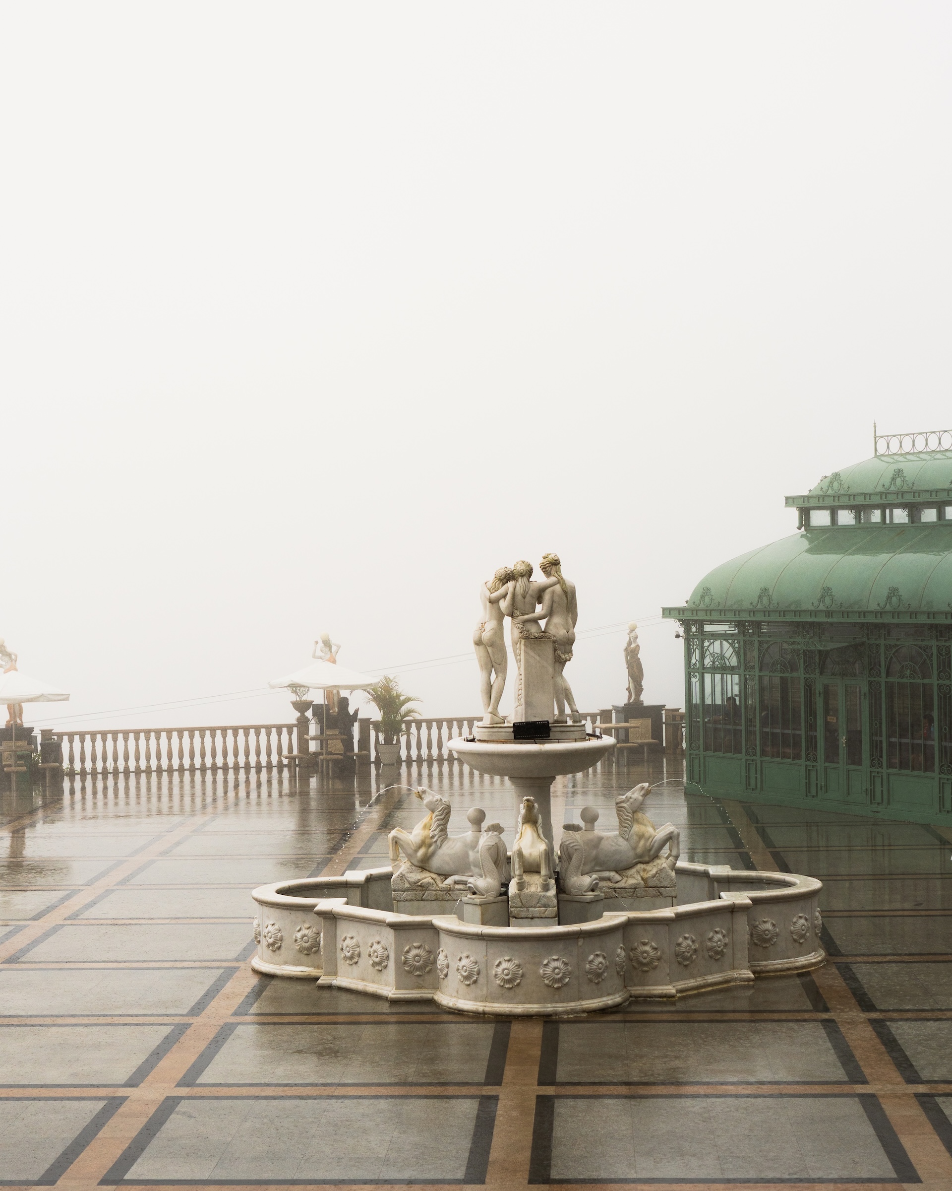 White marble fountain with classical sculptures at Temple of Leah Cebu in the mist and rain