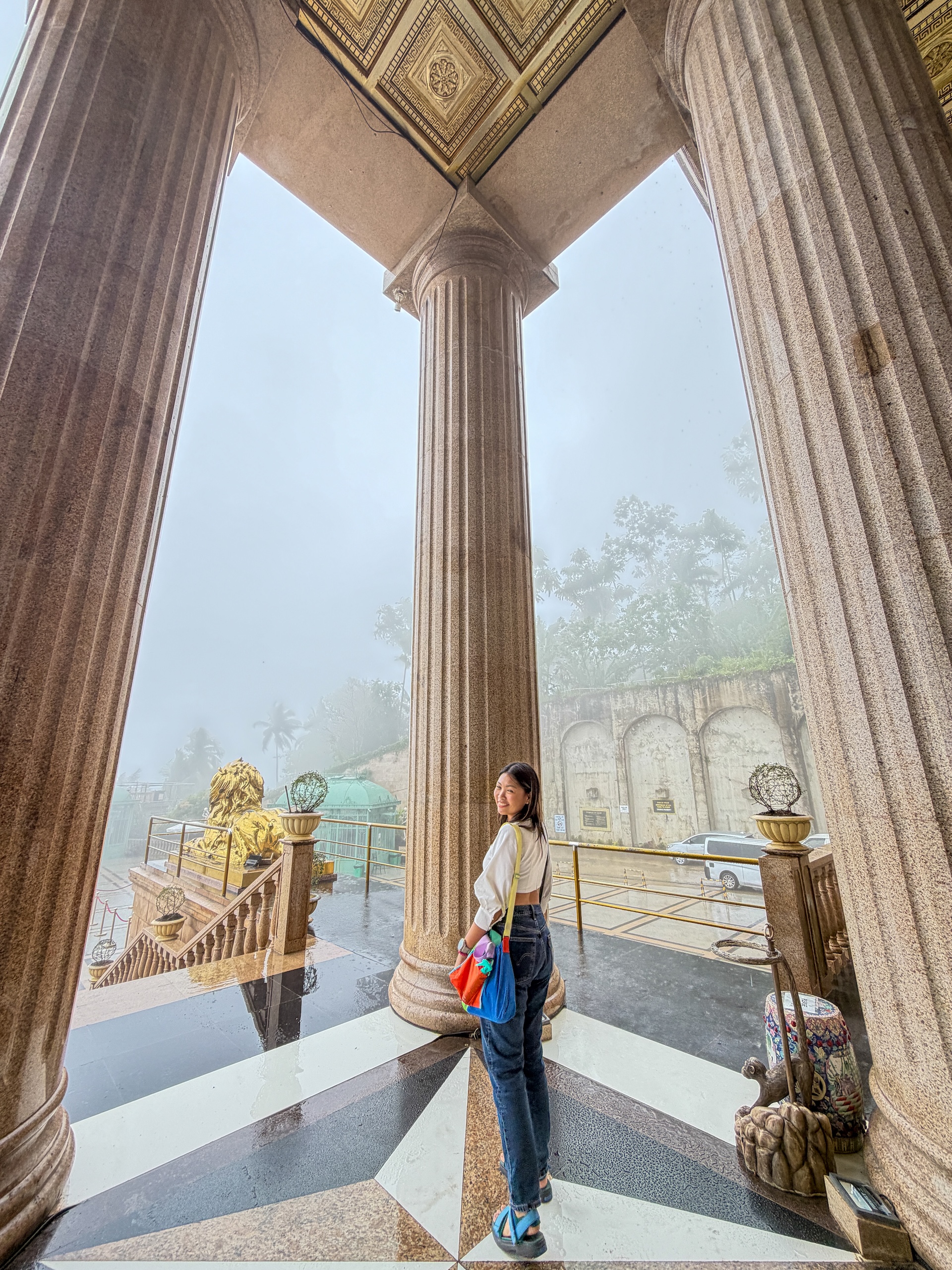 Standing between the grand Roman columns at Temple of Leah Cebu with foggy view outside