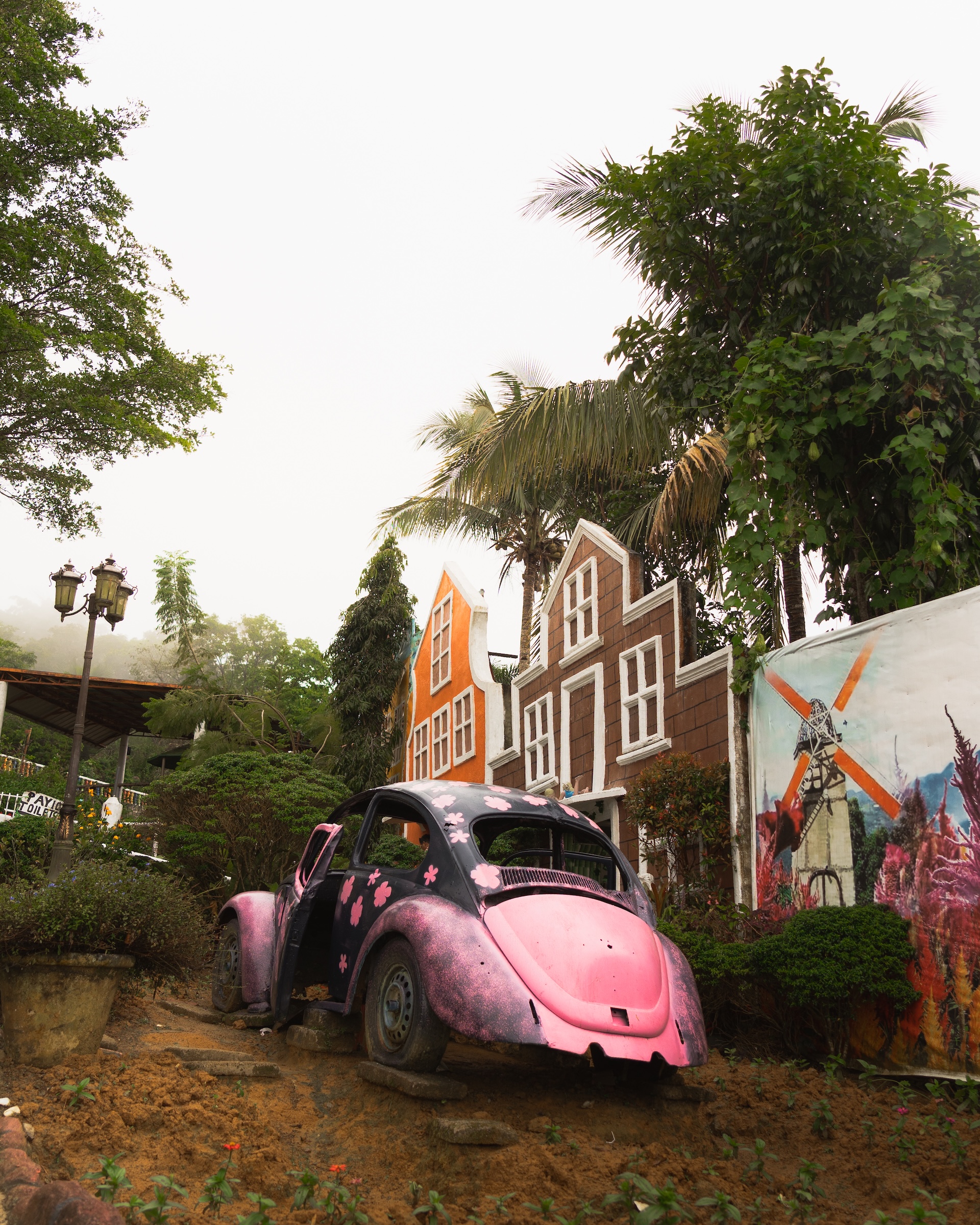 Pink Volkswagen Beetle car prop at Sirao Garden with Dutch-inspired colourful facade buildings behind
