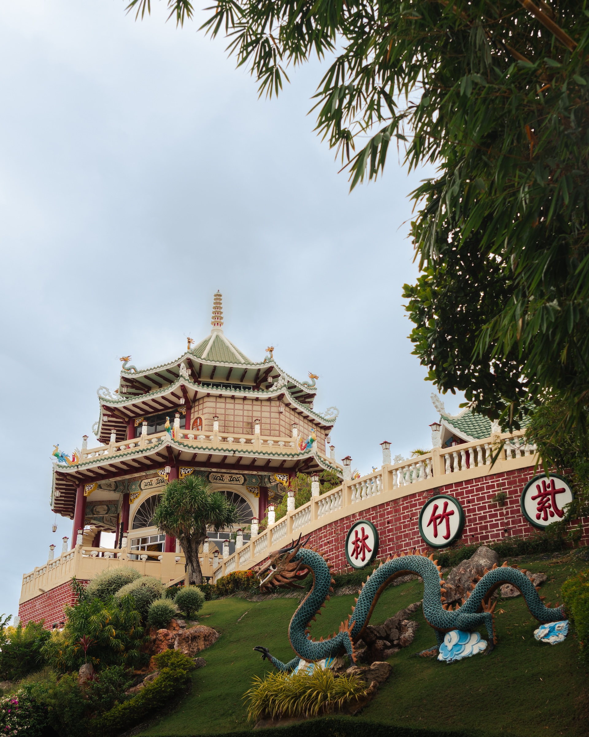 Multi-tiered Taoist Temple pagoda in Cebu with teal dragon sculpture on the hillside