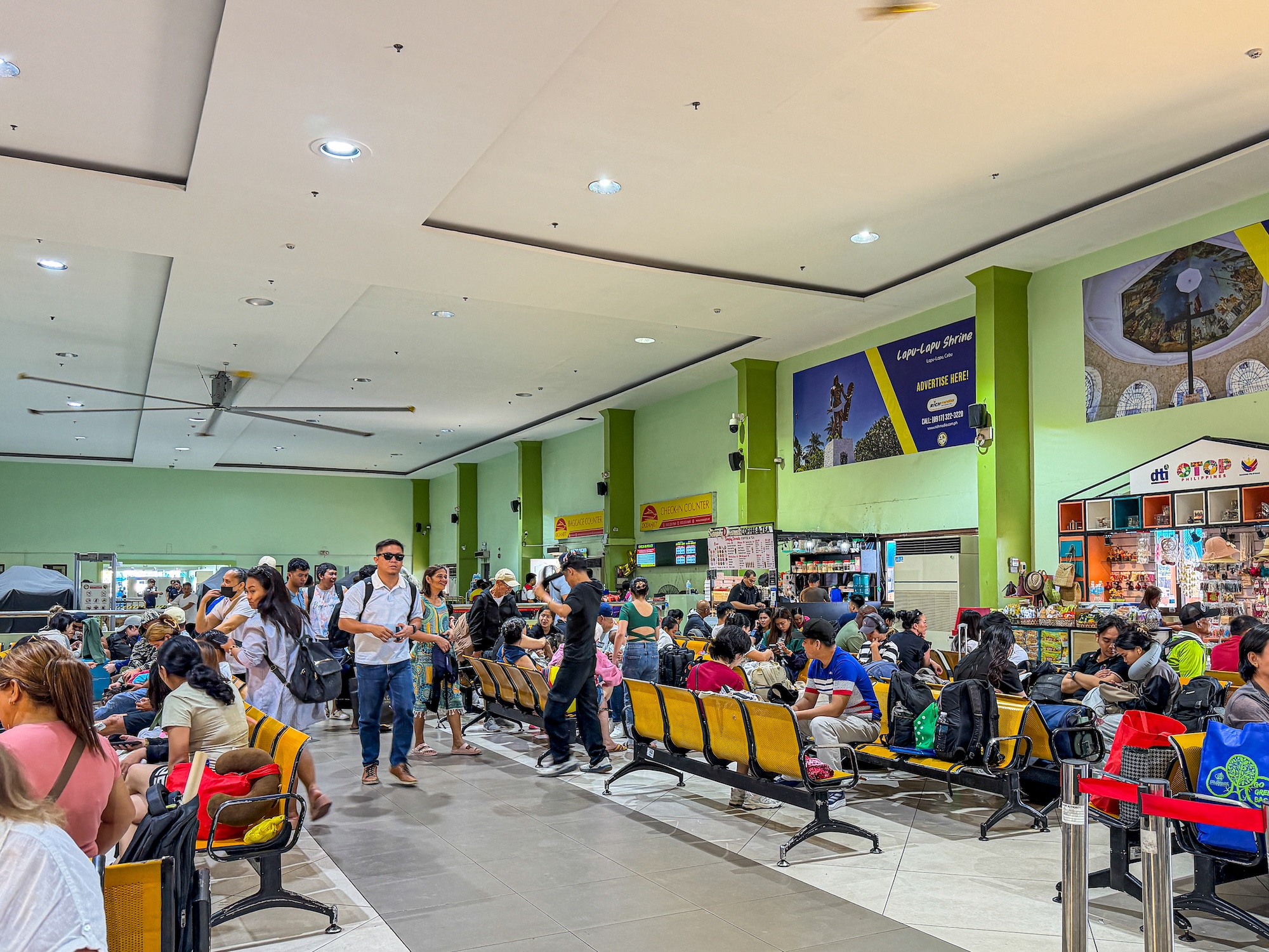 Crowded waiting area at the OceanJet ferry terminal with passengers and luggage before departure