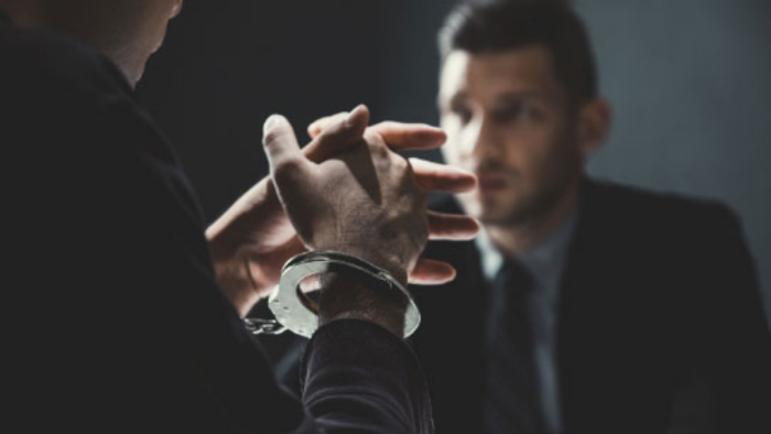 Person in handcuffs sat opposite lawyer