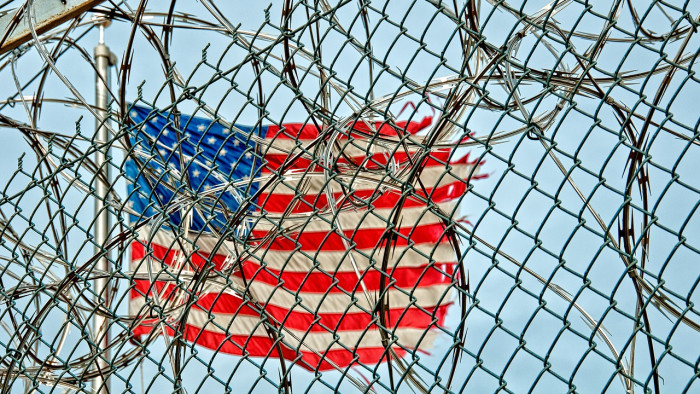 The US flag behind barbed wire