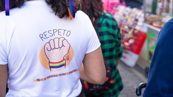 Image shows the back of a woman's t-shirt at a protest in Bogota. The shirt reads 'Respeto - no a la homofobia, bifobia y transfobia