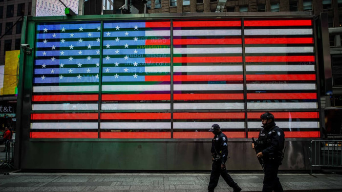 US flag with police walking in front