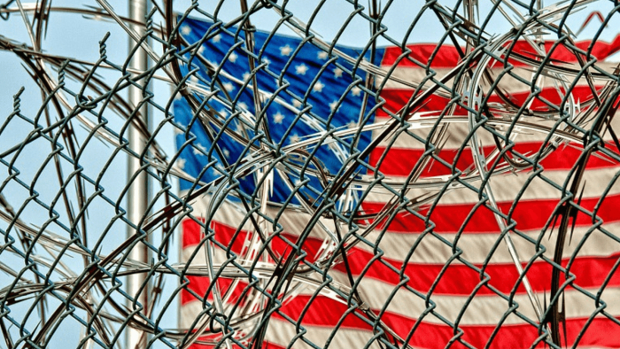 US flag behind barbed wire