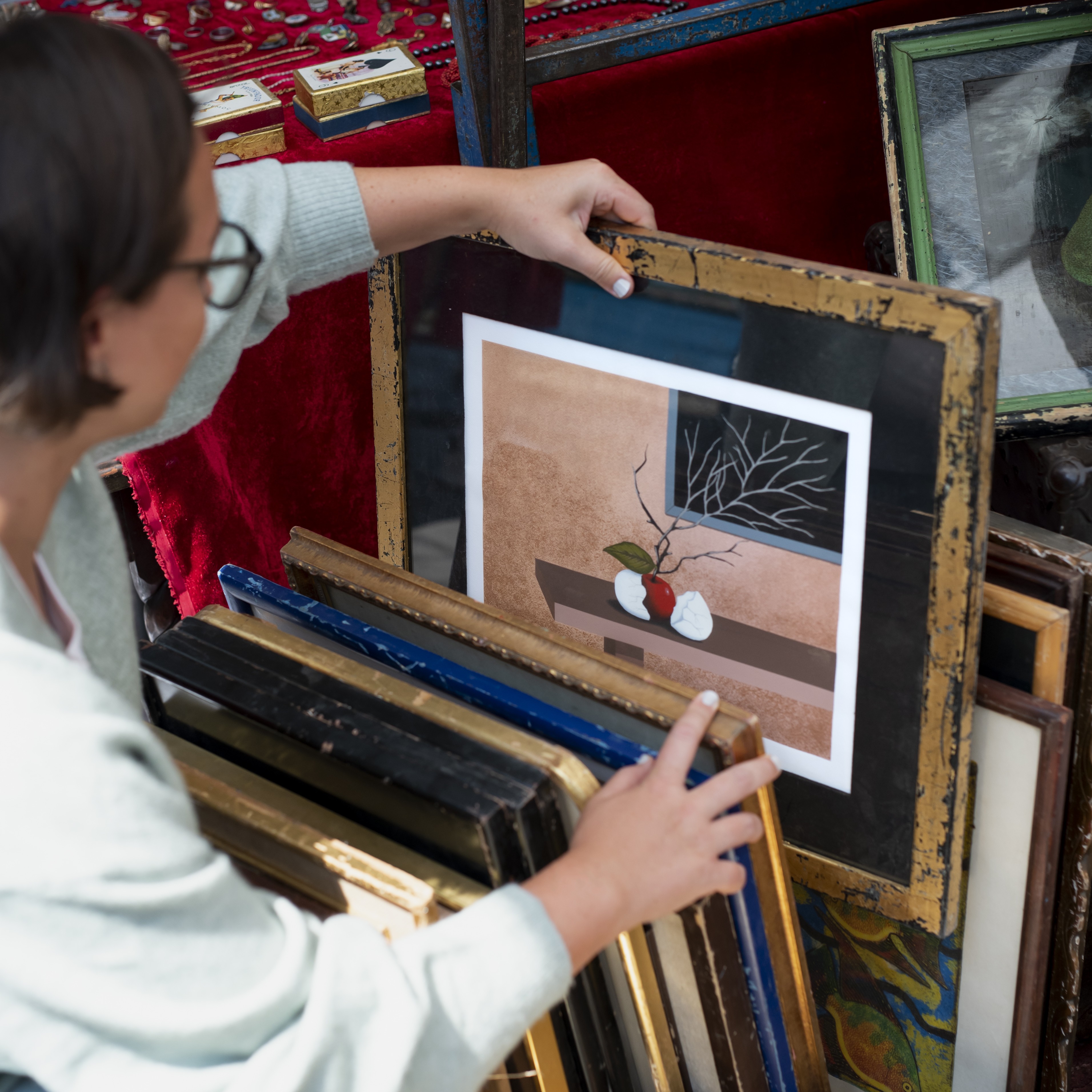 femme-regardant-la-peinture-au-marche-d-occasion