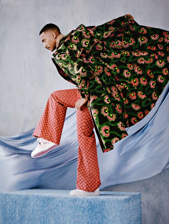 Gucci coat, turtleneck, and pants. Christian Louboutin sneakers. Ring, his own