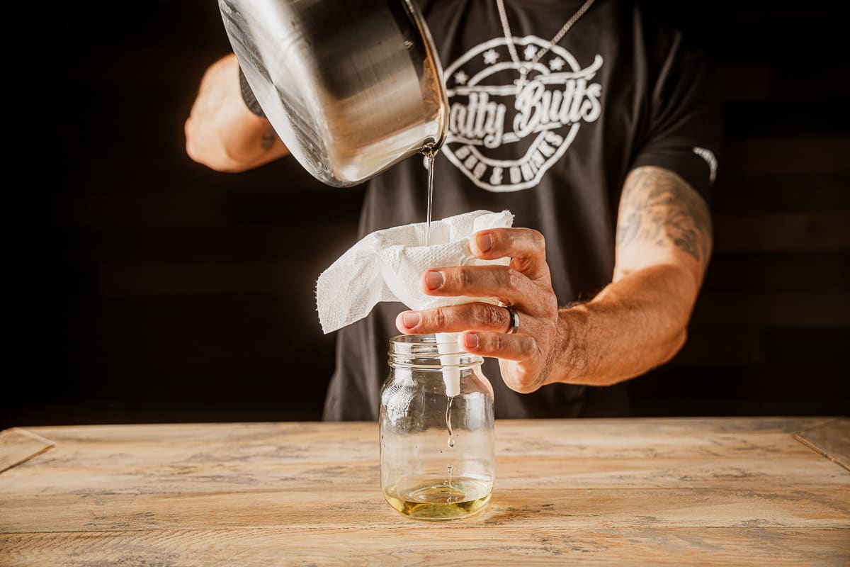 Pour beef tallow into mason jar