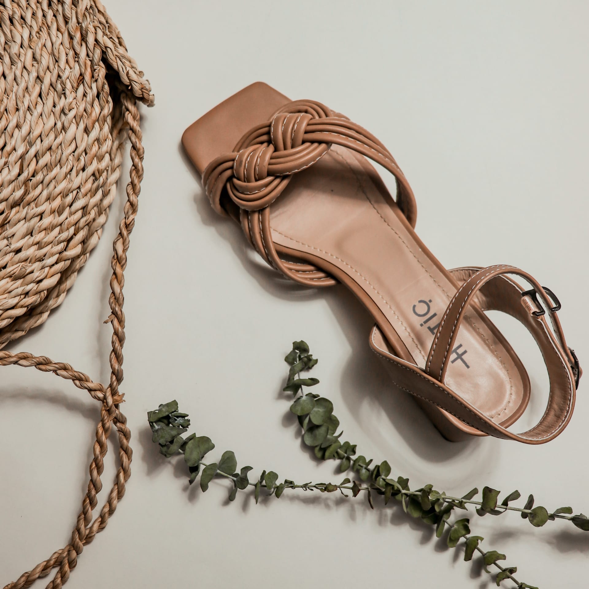 Brown shoes sitting next to rope and green vine