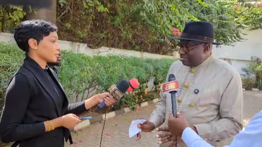 Yolanda Robert holding a microphone among other journalists during an outdoor press interview