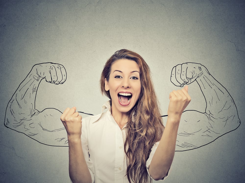 happy woman exults pumping fists ecstatic celebrates success on gray wall background Happy franchise employee celebrating