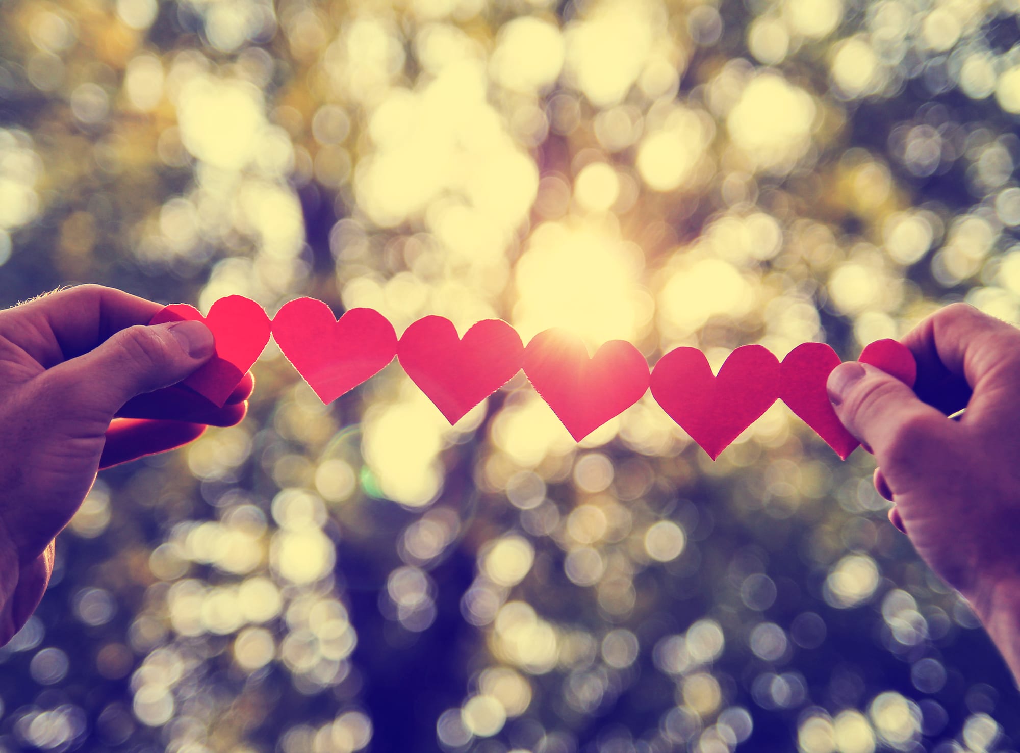 Depositphotos_65212987_l-2015 hands+holding+string+of+paper+hearts