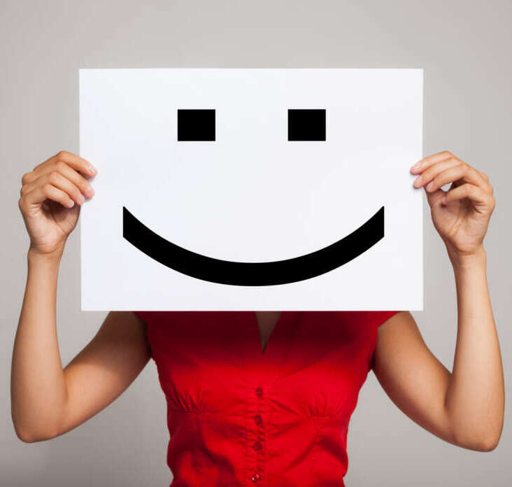 Smiling emoticon Woman holding a smiling face emoticon