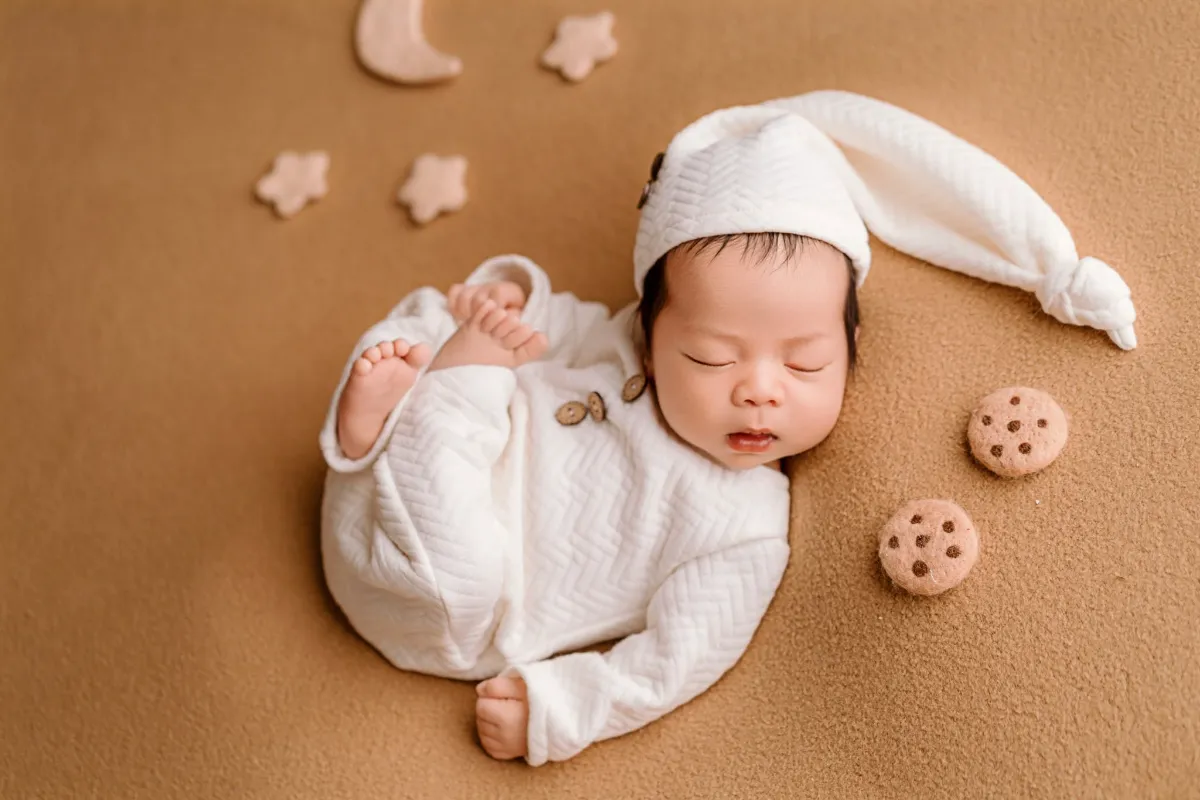 Bé một tháng tuổi nằm chơi tỉnh táo trong buổi chụp ảnh đầy tháng cho bé
