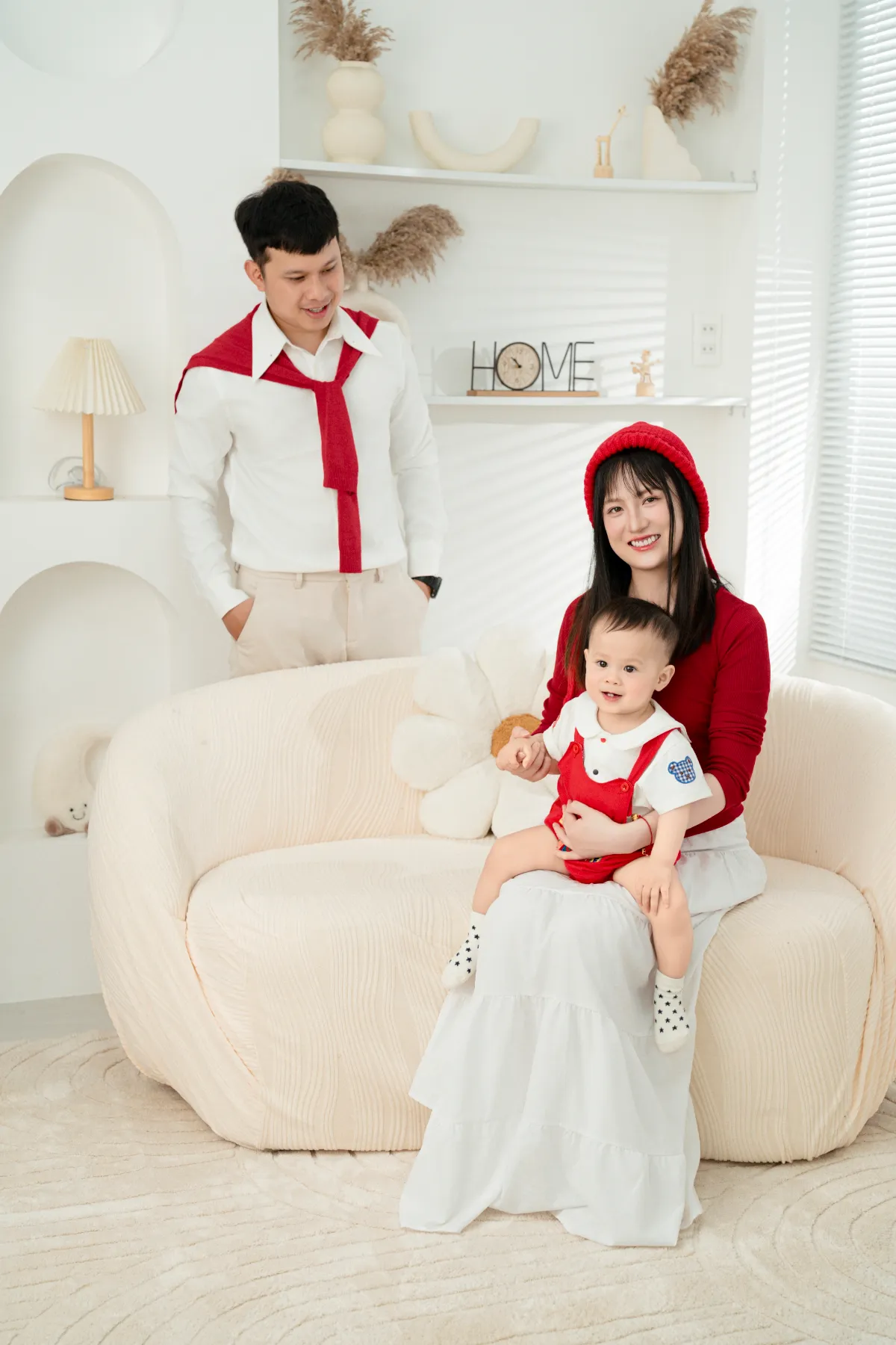 Cả nhà cùng nhau dạo chơi trong cuối tuần Đà Lạt cùng bé — mẹ bế bé, ba đứng bên cạnh mỉm cười