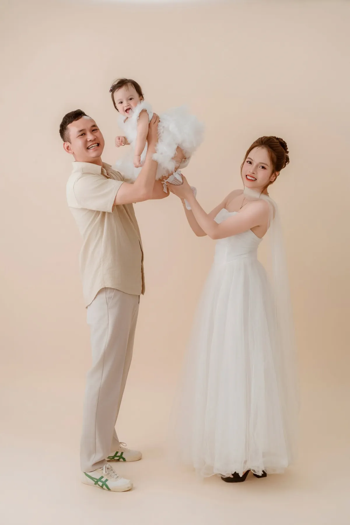 Ba nâng bé lên cao, mẹ cười bên cạnh — cuối tuần Đà Lạt cùng bé, ngắm tàu là trò đơn giản mà bé rất thích
