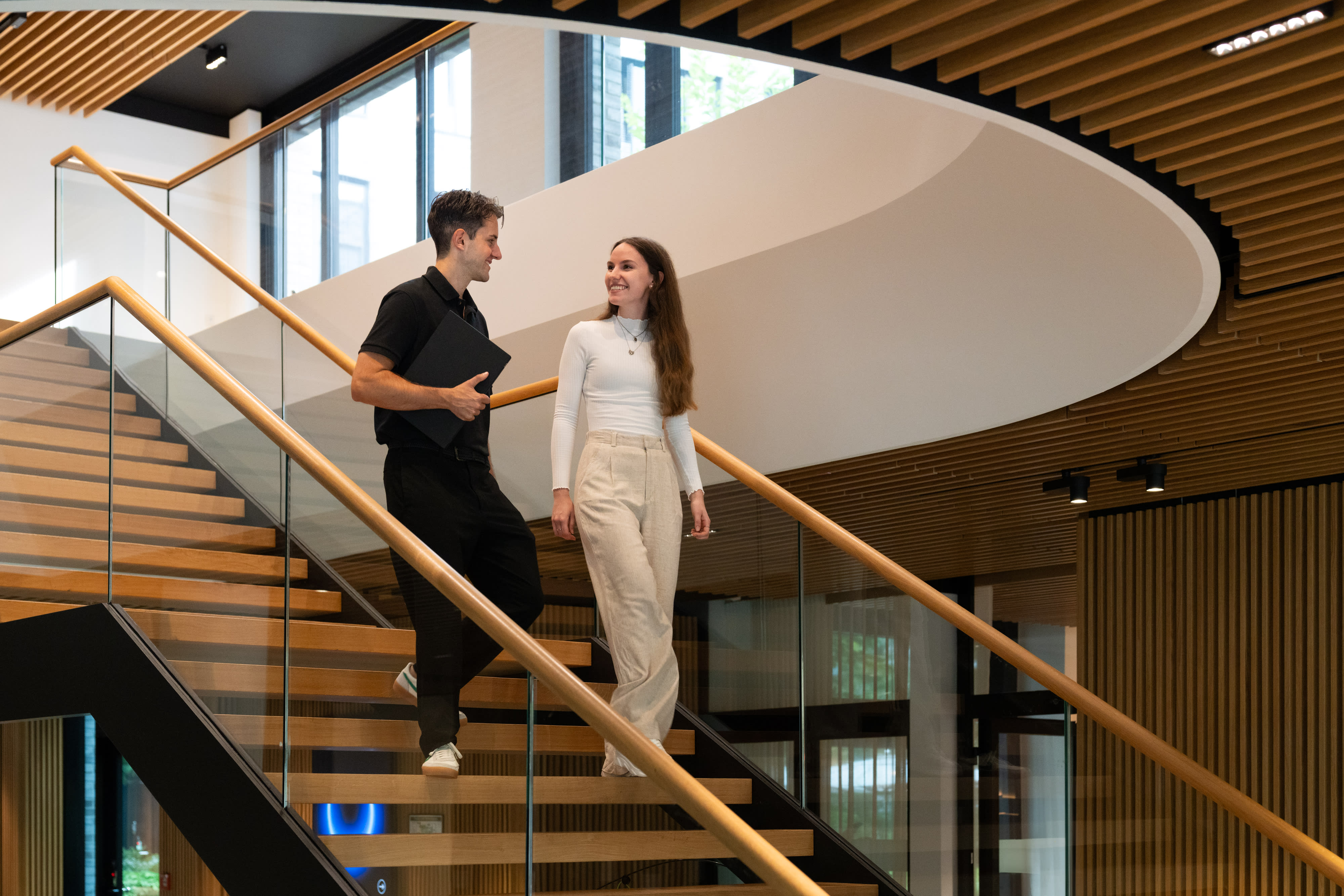 Zwei Kolleg:innen, die eine Treppe runtergehen