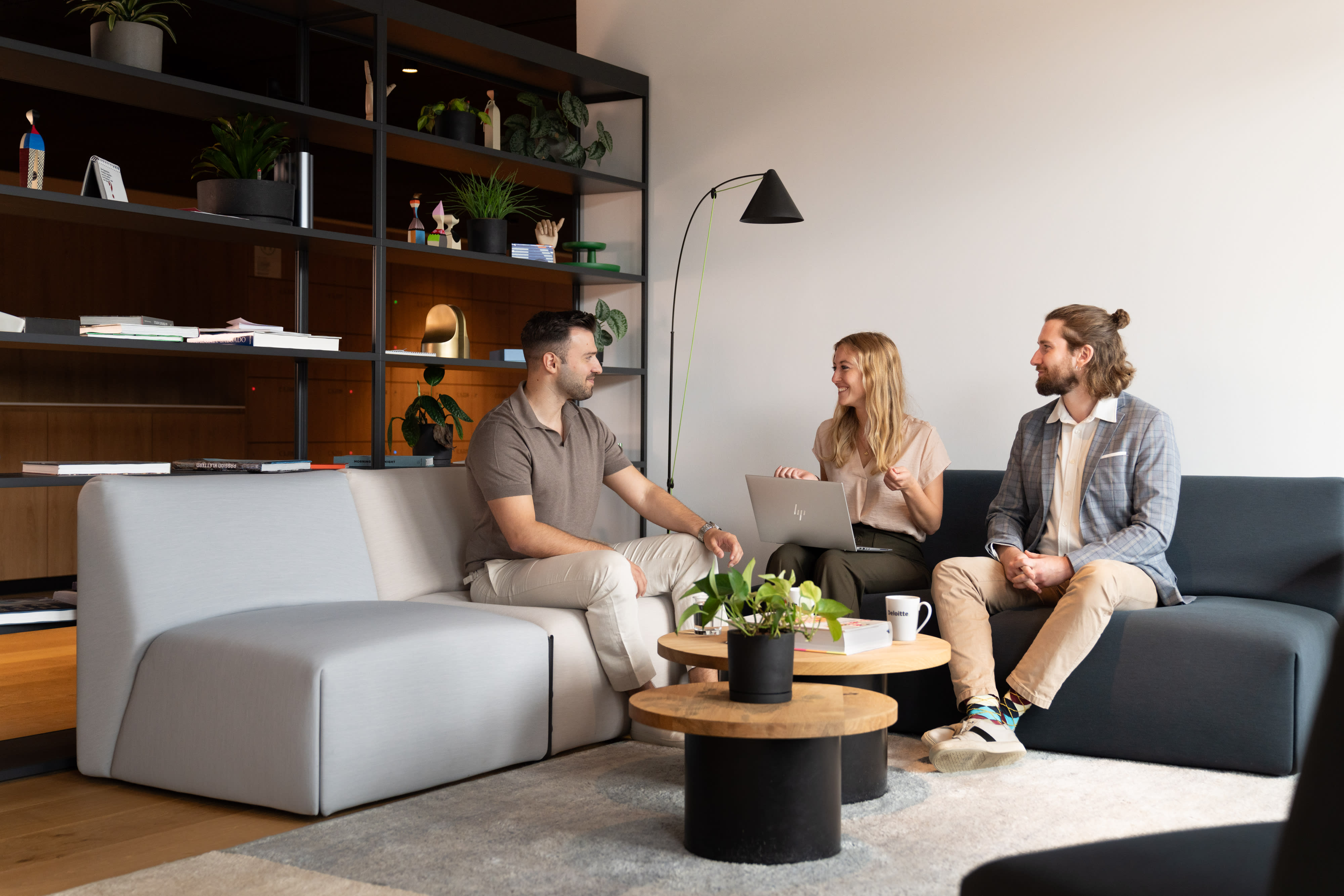 Drei Kolleg:innen, die sich auf einem Sofa unterhalten