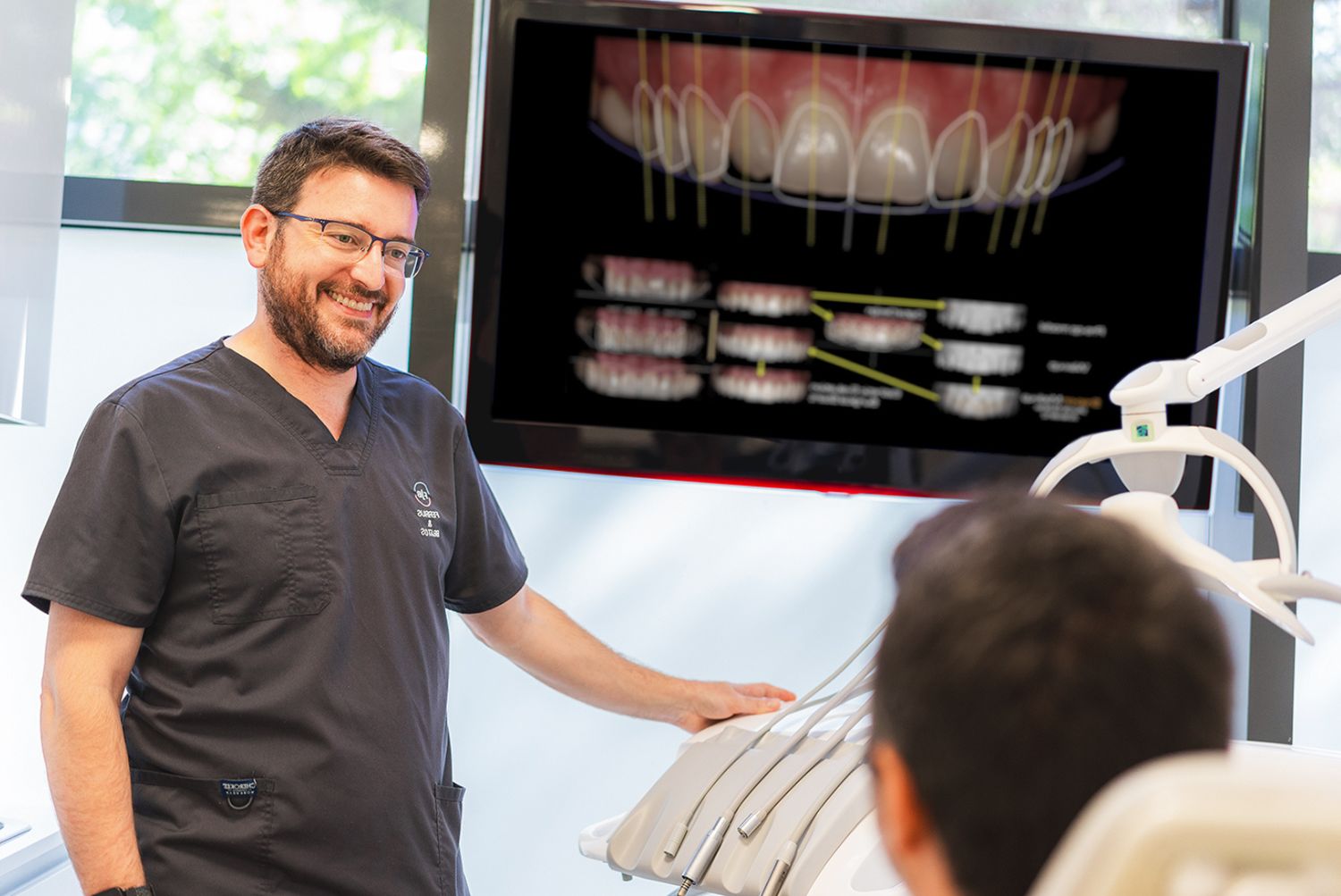 Doctor con paciente explicando un diseño de sonrisa