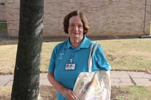 A North Tees clinical volunteer holds a patient-designed tote bag decorated with fruit illustrations.