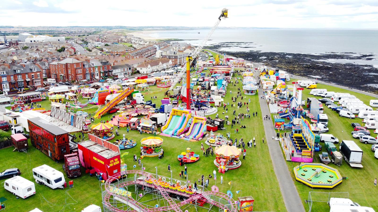 Aerial view of Hartlepool Carnival on the Headland, with fairground attractions beside the coast