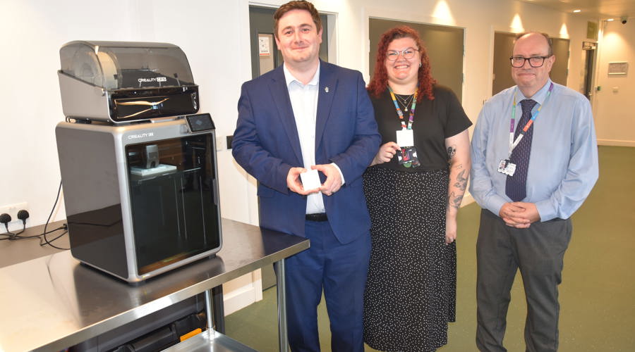 A 3D printer in Middlesbrough Central Library's public Makerspace with library staff