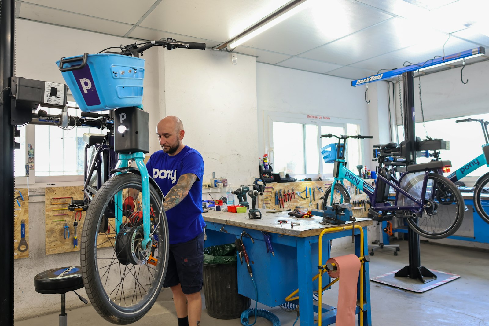 A bicycle mechanic carrying out repairs in a workshop, used as a representative image for free cycle maintenance sessions