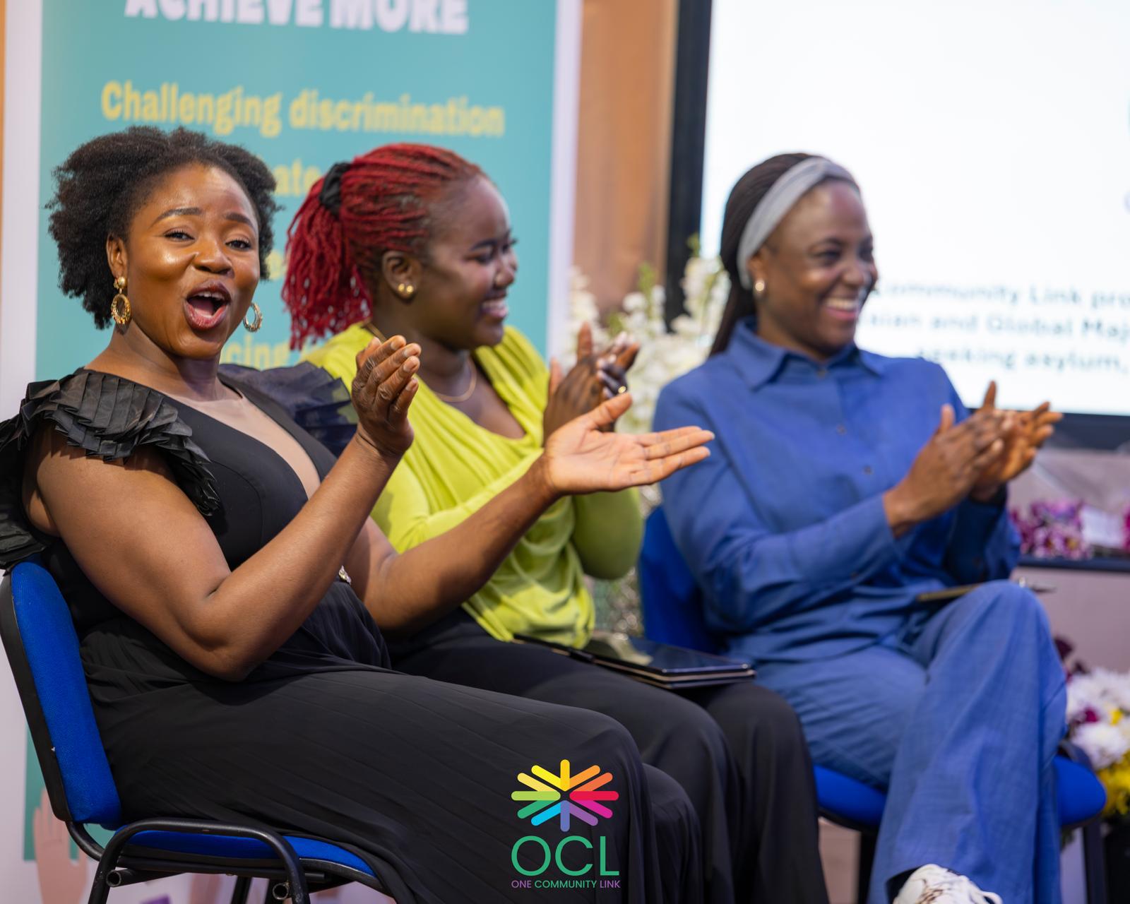 People taking part in a One Community Link event applaud during a session.